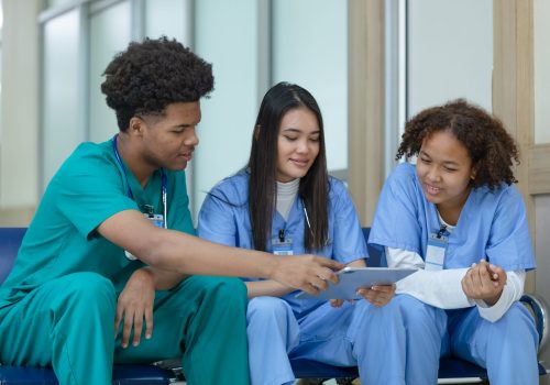 Group of medical student using tablet searching information stud Group of medical student using tablet searching information study and talking in hospital university. education and learning medical concept.